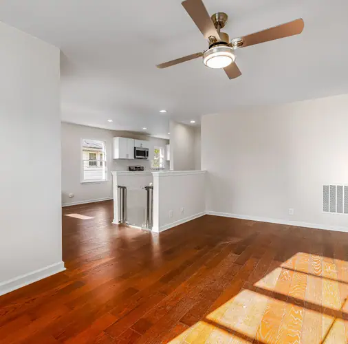 An empty apartment living room with wood floors after a move-out