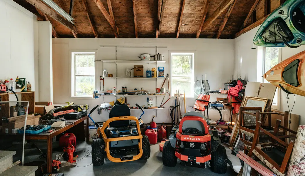 A two-car garage packed with mowers, furniture and boxes
