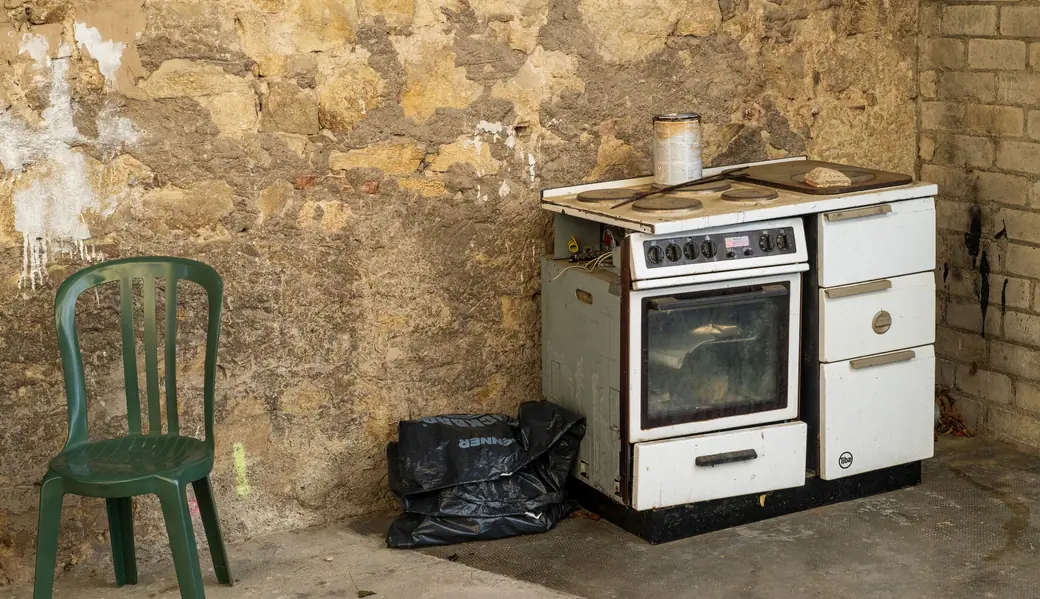 An old white stove in the corner of a rustic kitchen